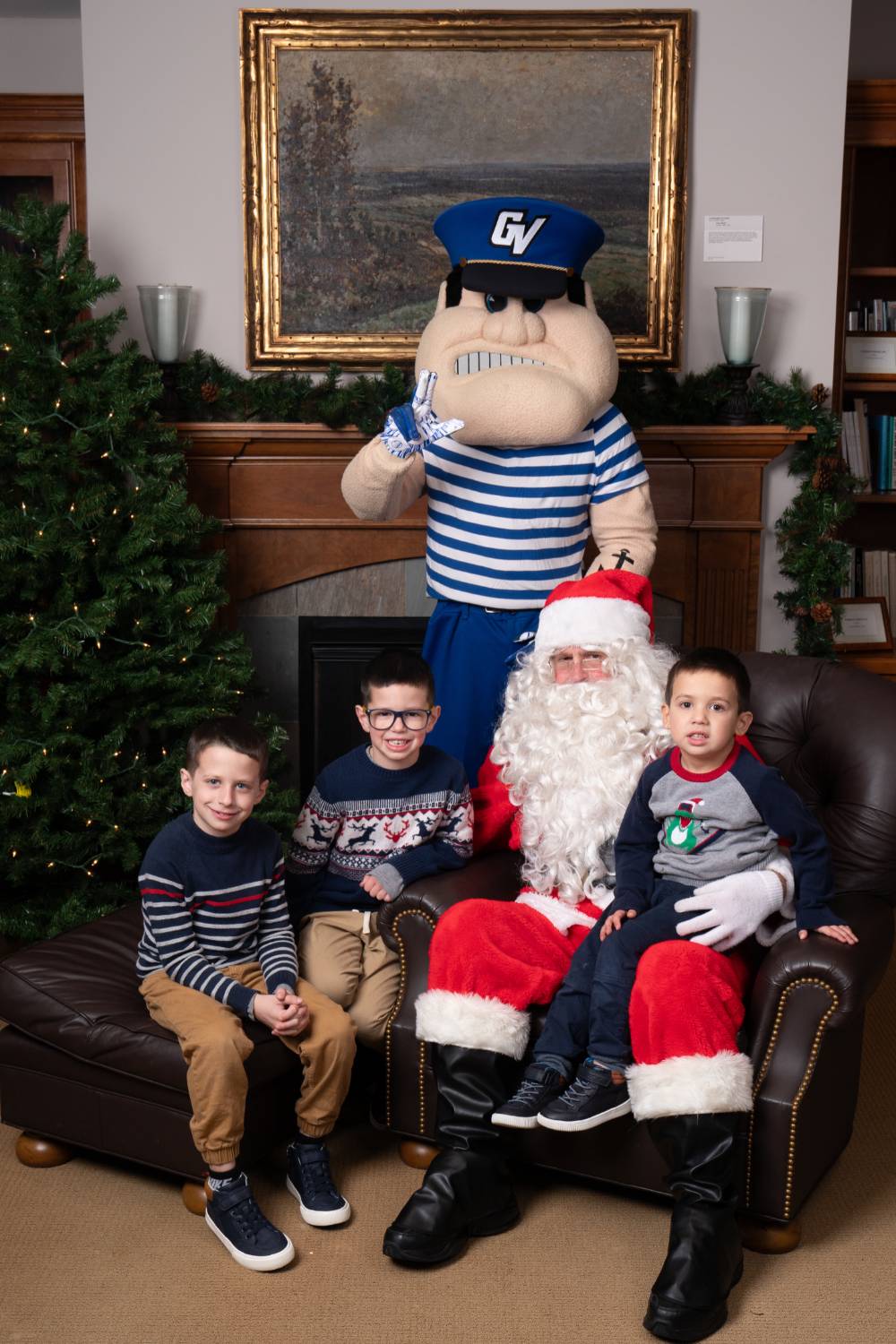 Three kids with Santa and Louie the Laker.